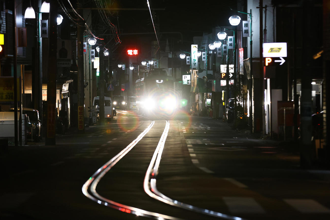 線路を照らし、腰越商店街を走る（撮影・大野祥一）