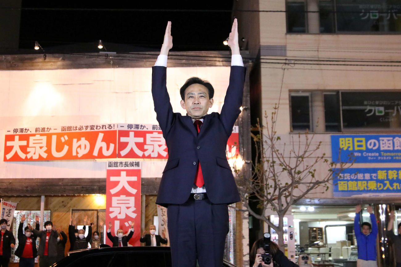 函館市長選の当選が確実となり、市内の後援会事務所前の広場でバンザイする大泉氏（撮影・山崎純一）