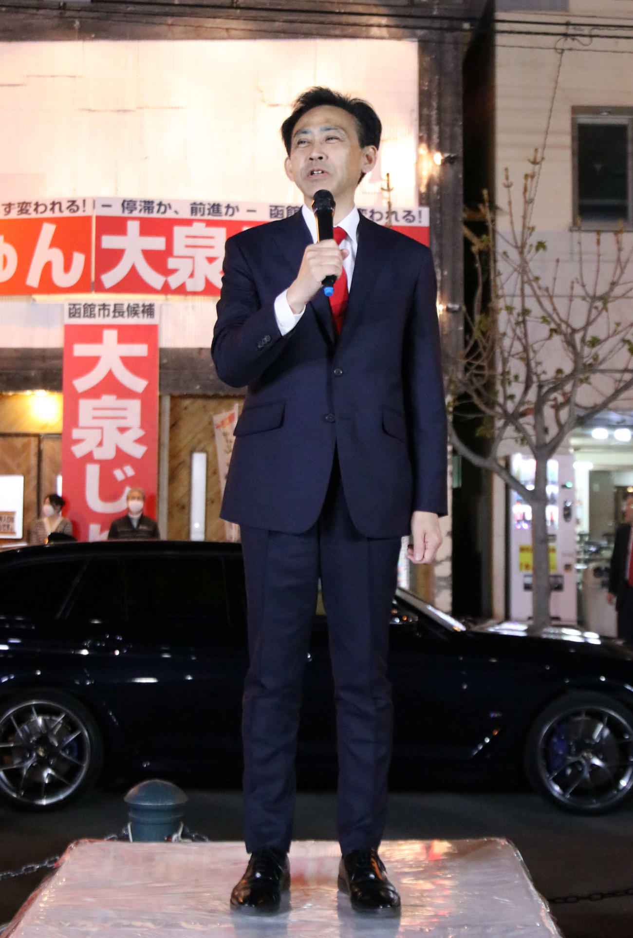 函館市長選で当選が確実となり、市内の後援会事務所前の広場であいさつする大泉氏（撮影・山崎純一）