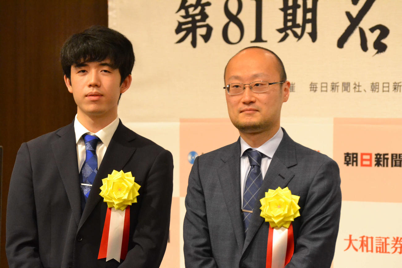 前夜祭で詰めかけたファンの前で記念撮影に応じる藤井聡太竜王（左）と渡辺明名人（右）