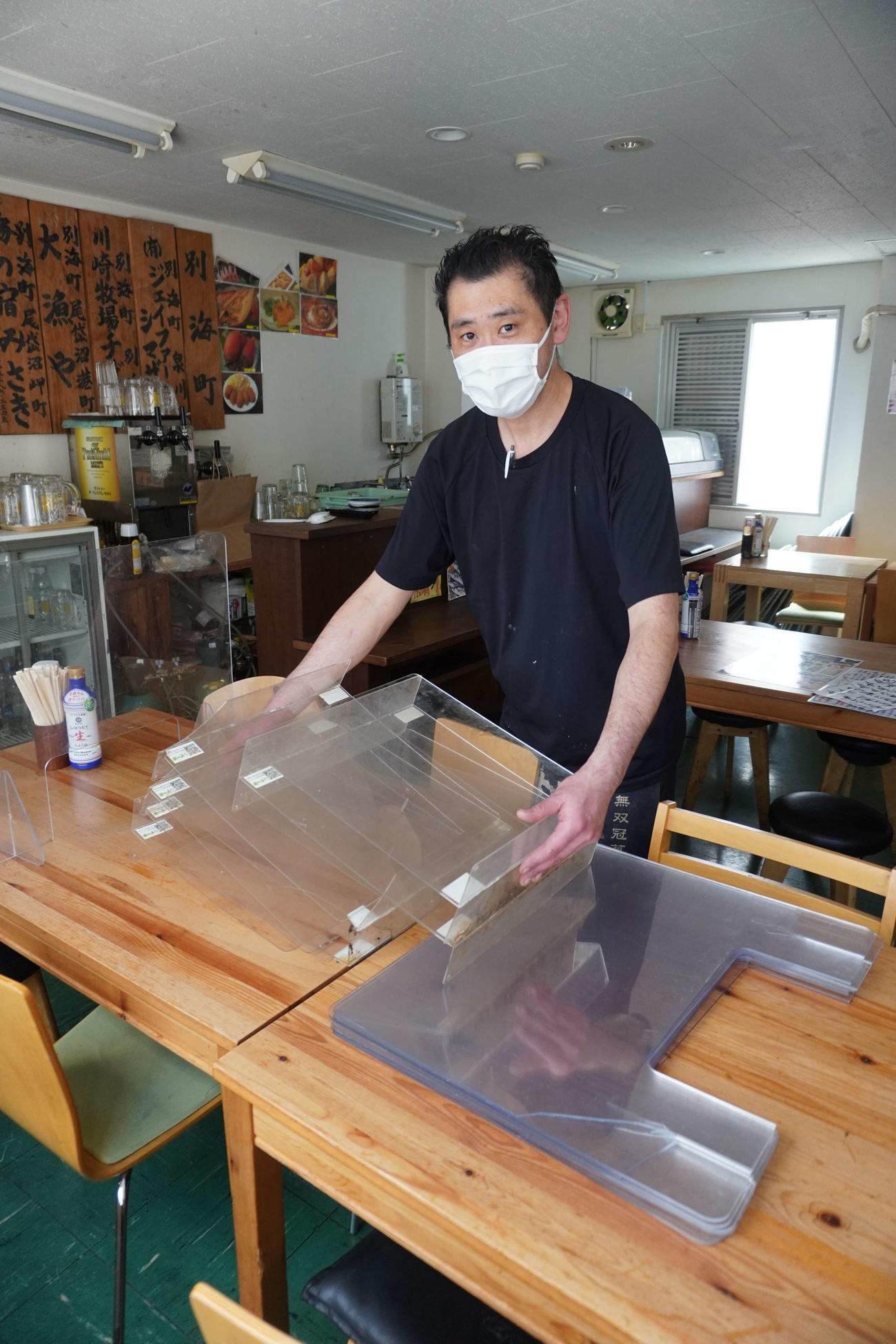 新型コロナ禍で使用していたアクリル板を撤去し店内に保管している「根室食堂　新橋店」の平山徳治店主（撮影・沢田直人）
