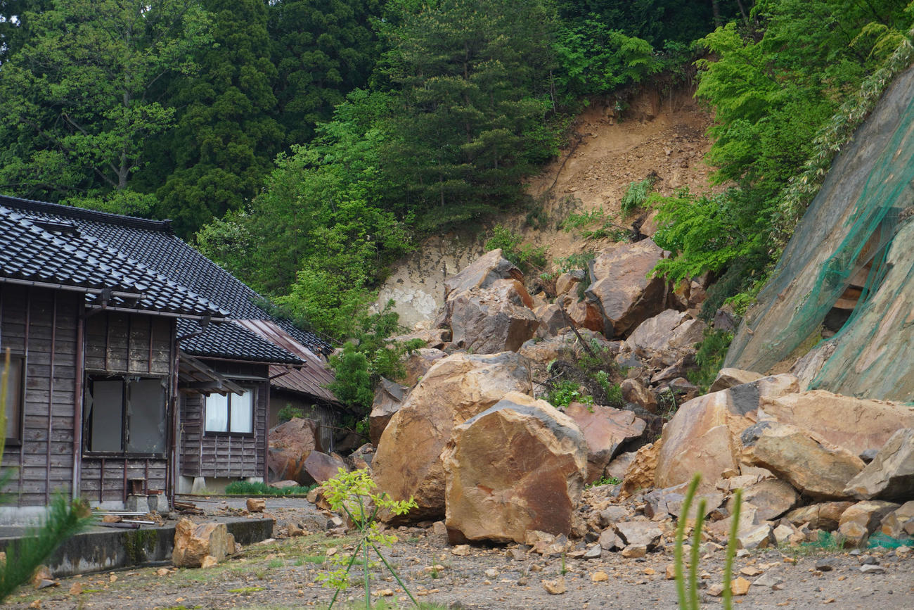 山の一部が崩れ落ち、大きな岩が住宅に達していた＝珠洲市（撮影・沢田直人）