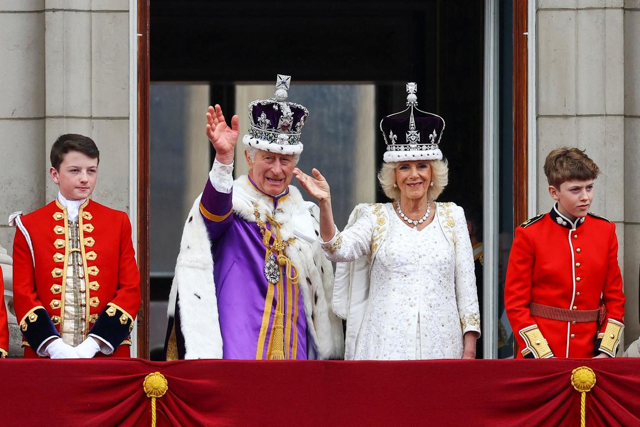 バッキンガム宮殿のバルコニーで手を振る英国王チャールズとカミラ王妃（ロイター）