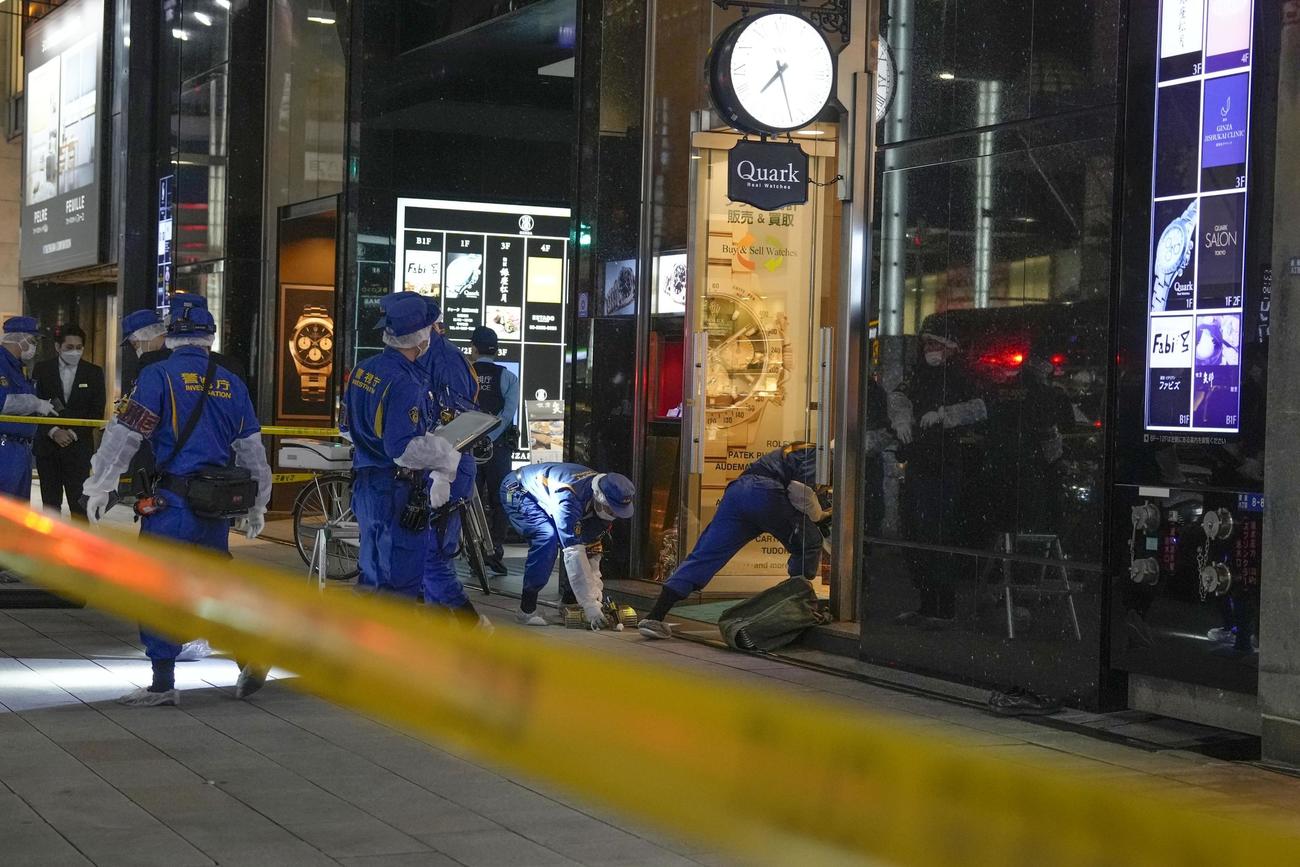 男らが押し入った東京・銀座のロレックス専門店「クォーク銀座888店」前を調べる警視庁の捜査員（共同）