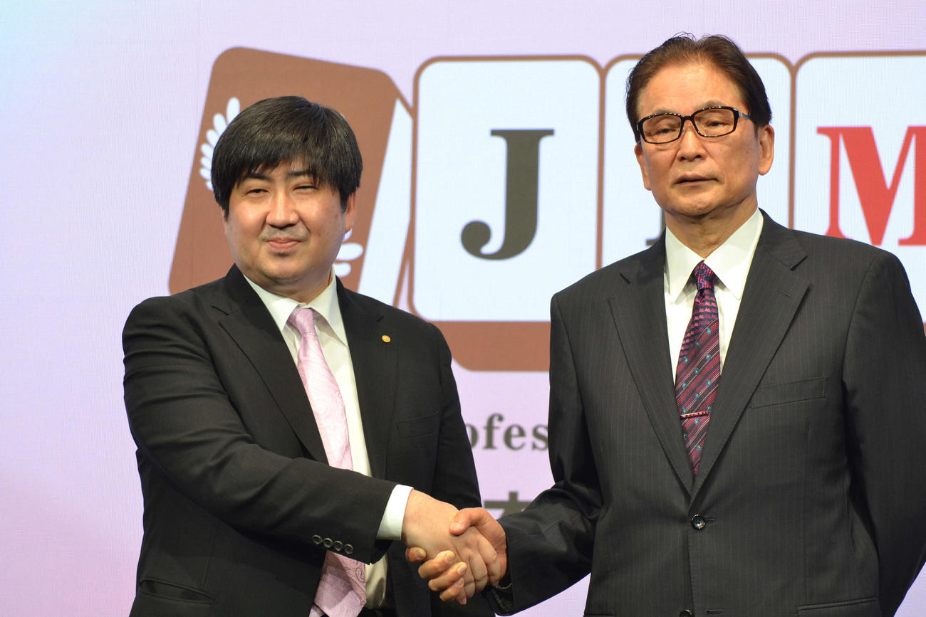 「日本プロ麻雀連盟」のプロ雀士としての資格を得て将棋と「二刀流」宣言をした鈴木大介九段（左）は同連盟の森山茂和会長（右）と握手を交わす