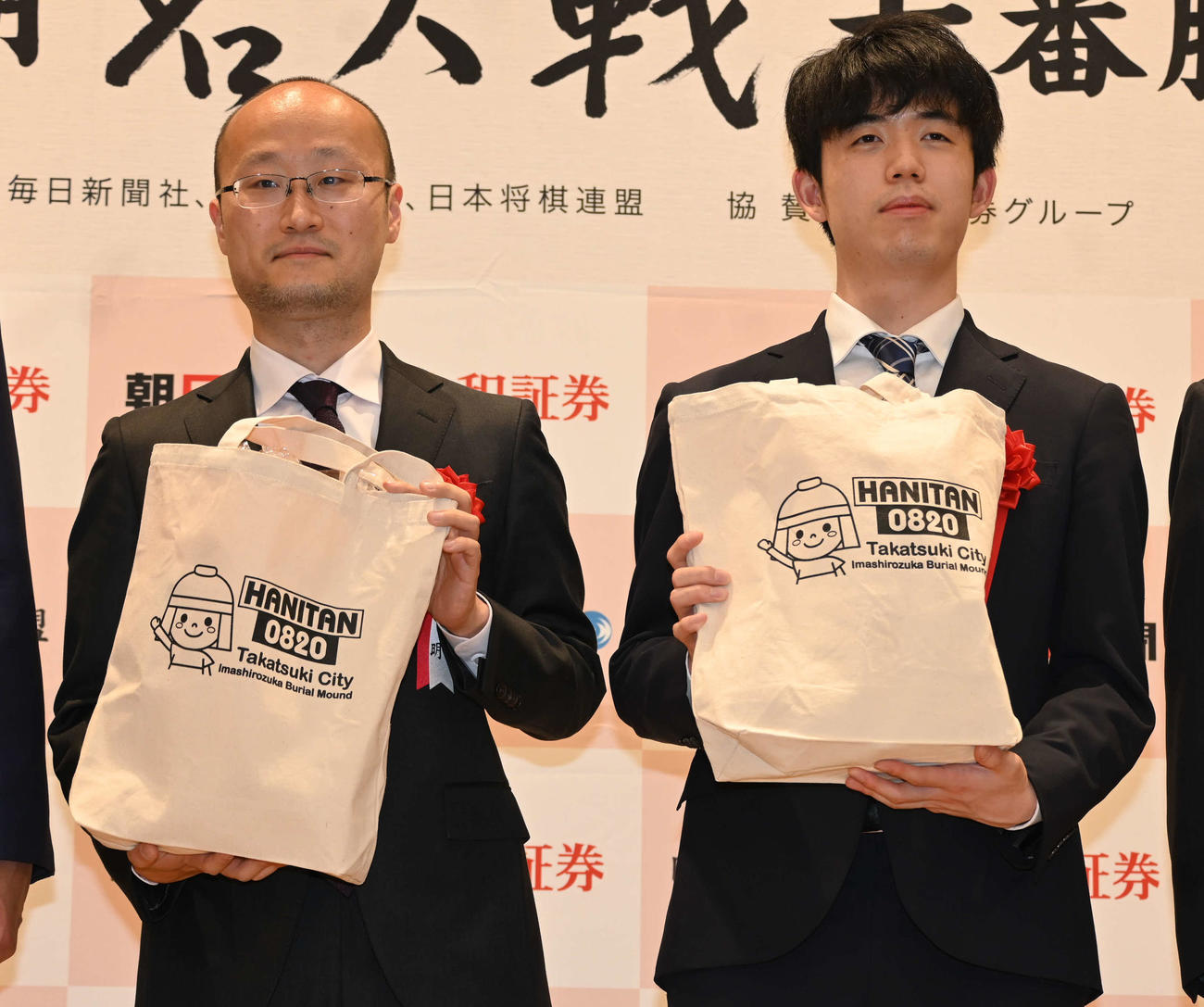 高槻市マスコットキャラクター「はにたん」グッズを贈呈された渡辺明名人（左）と藤井聡太竜王（撮影・松浦隆司）