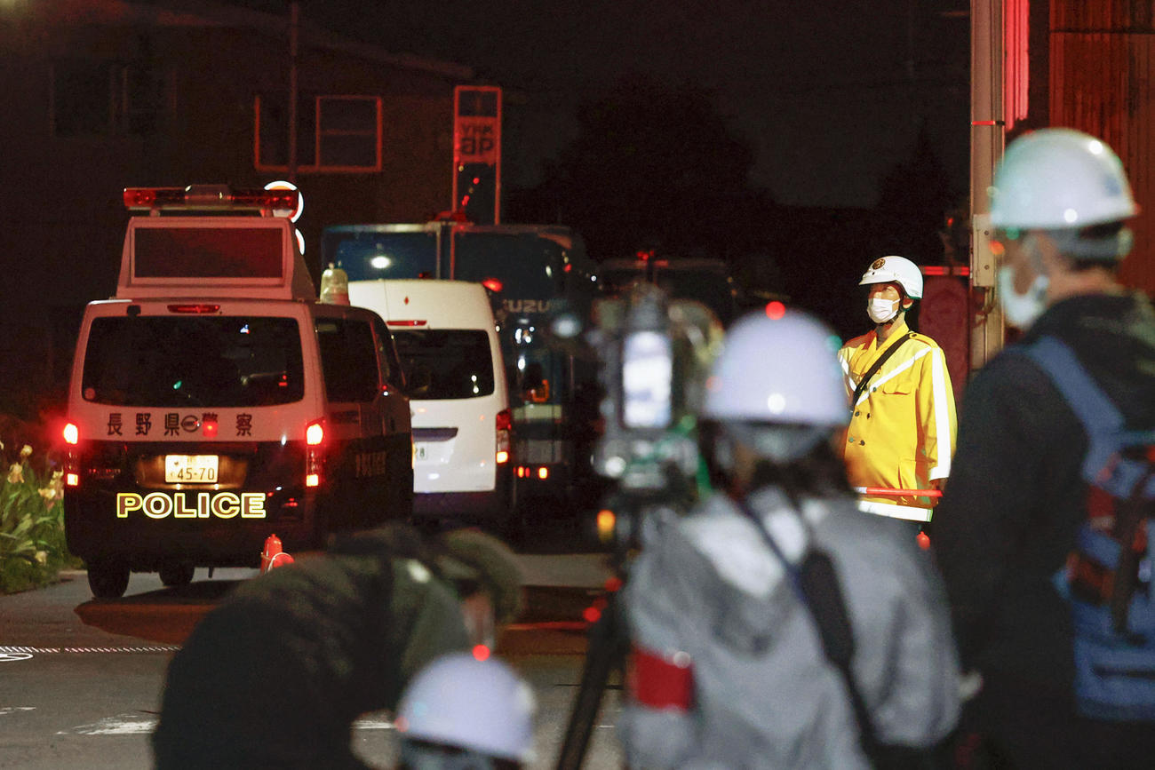 男が立てこもった現場付近で警戒する警察官。手前は報道陣（共同）