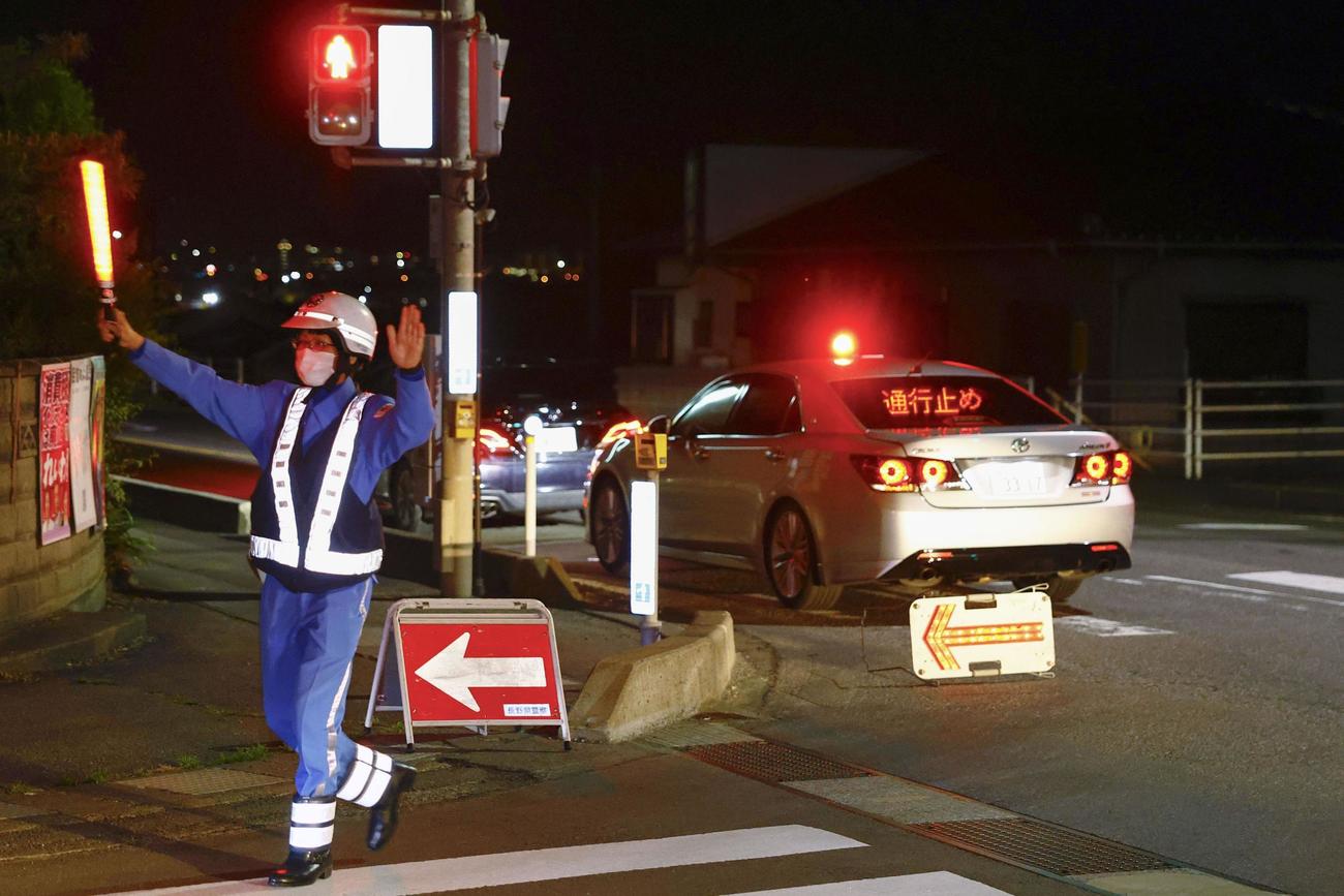 事件があった現場周辺を交通規制する警察官（共同）