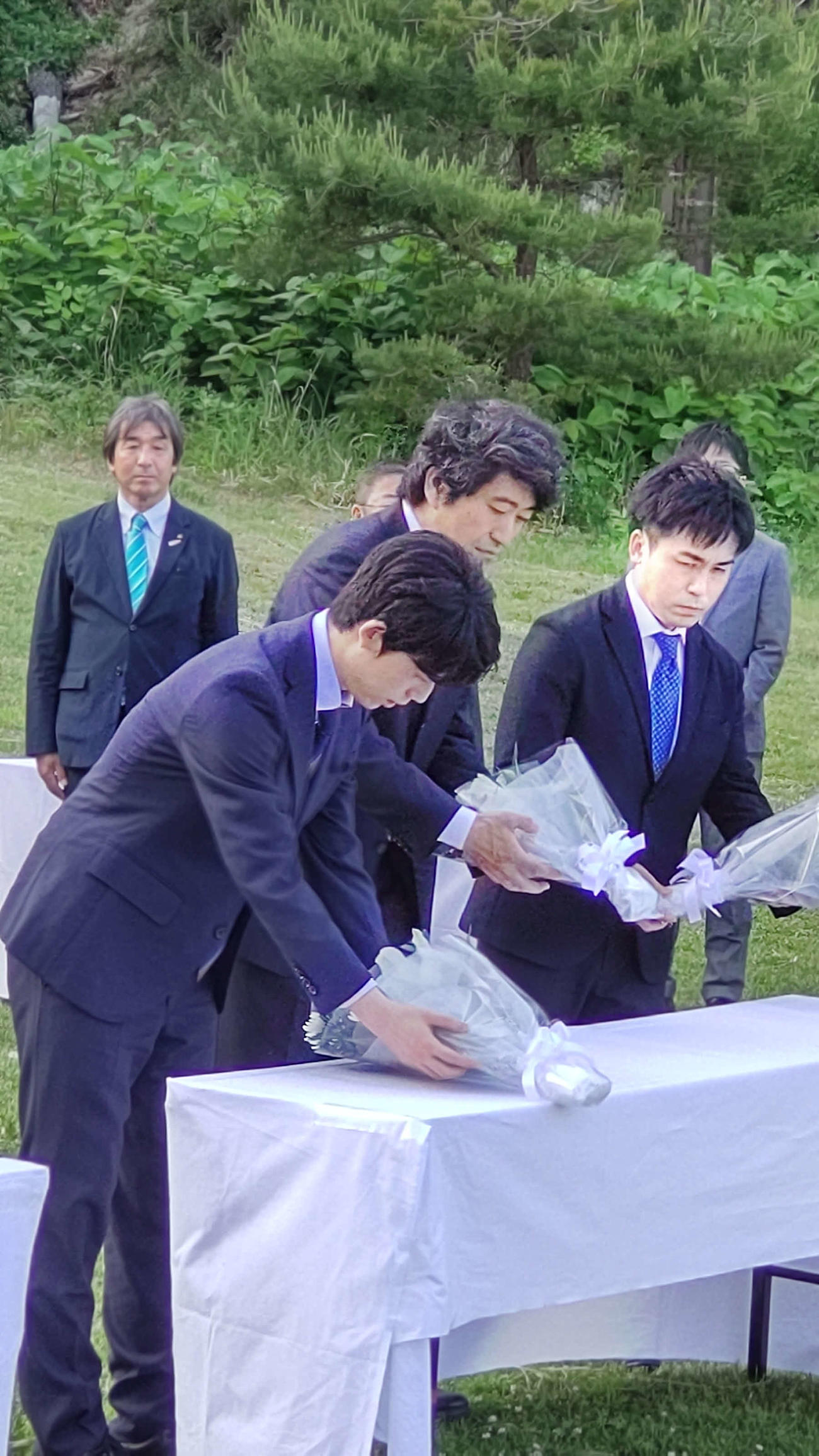 叡王戦第4局の前日に浄土ケ浜レストハウス前で献花を行った藤井聡太叡王、立会人の森内俊之九段、菅井竜也八段（左から）