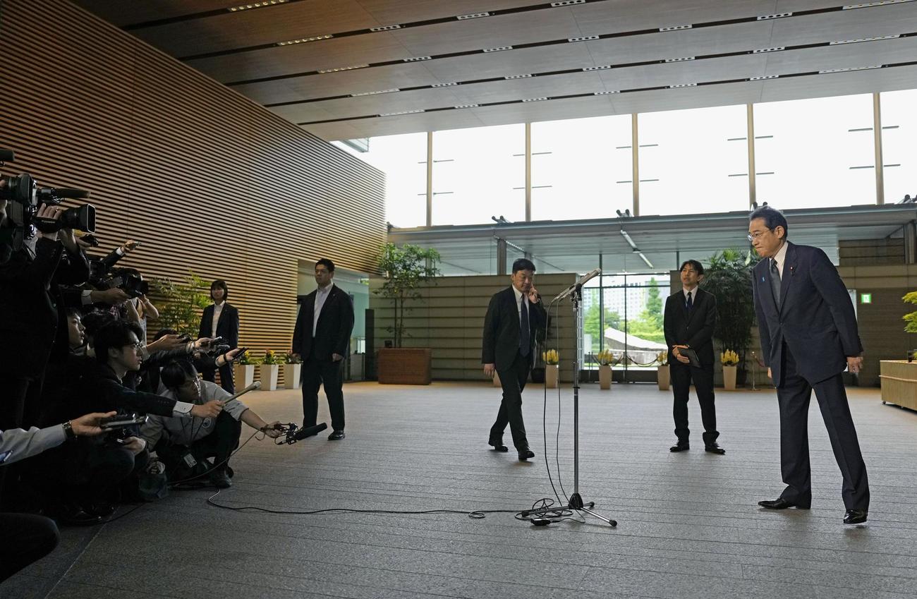 官邸で記者の質問に答える岸田首相（右端）（共同）