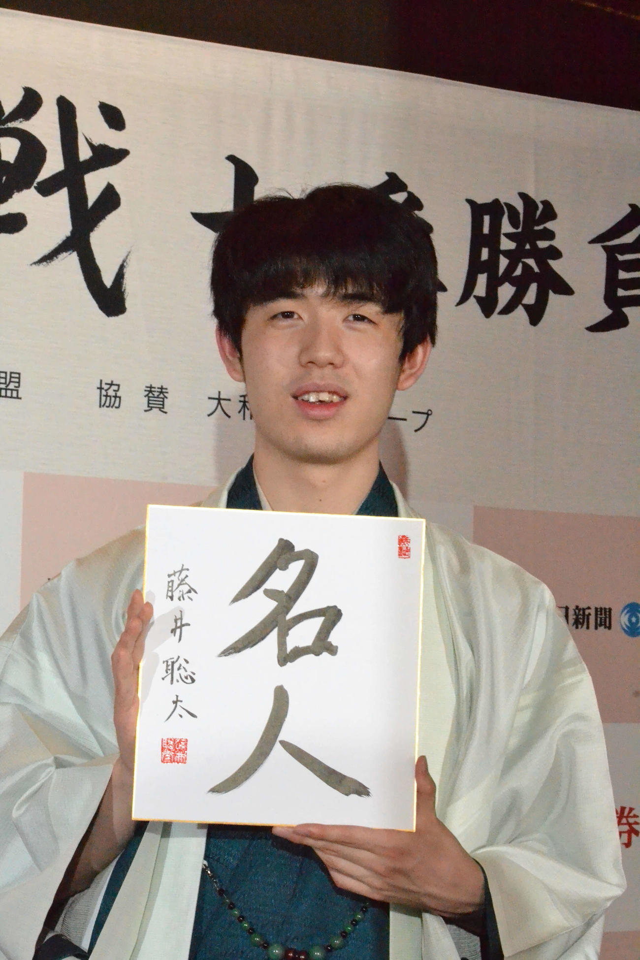 初仕事として「名人」と揮毫（きごう）した色紙を手に撮影に応じる藤井聡太新名人（撮影・赤塚辰浩）