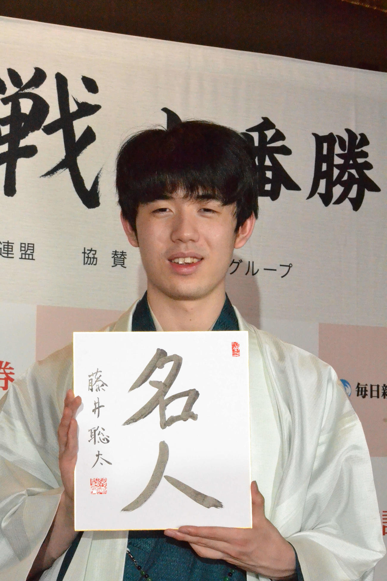 初仕事として「名人」と揮毫（きごう）した色紙を手に撮影に応じる藤井聡太新名人（撮影・赤塚辰浩）
