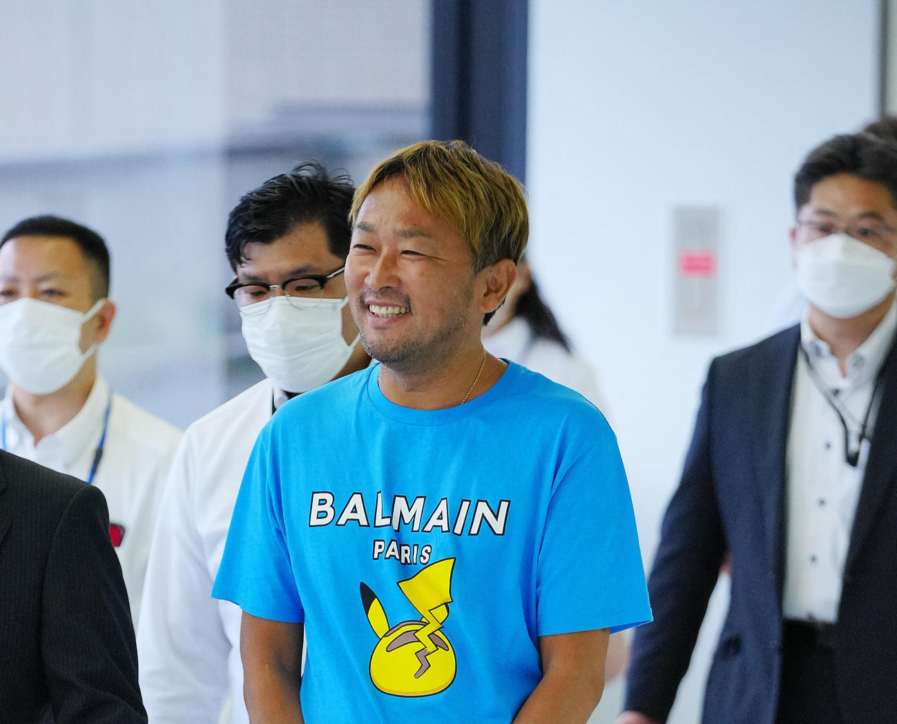 帰国し逮捕されたガーシーこと東谷義和容疑者（中央）は捜査員と談笑しながら移動する（撮影・垰建太）