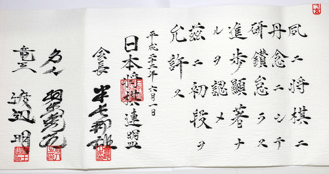 日本将棋連盟の免状。平成22年の実物。署名は右から「会長　米長邦雄」「名人　羽生善治」「竜王　渡辺明」