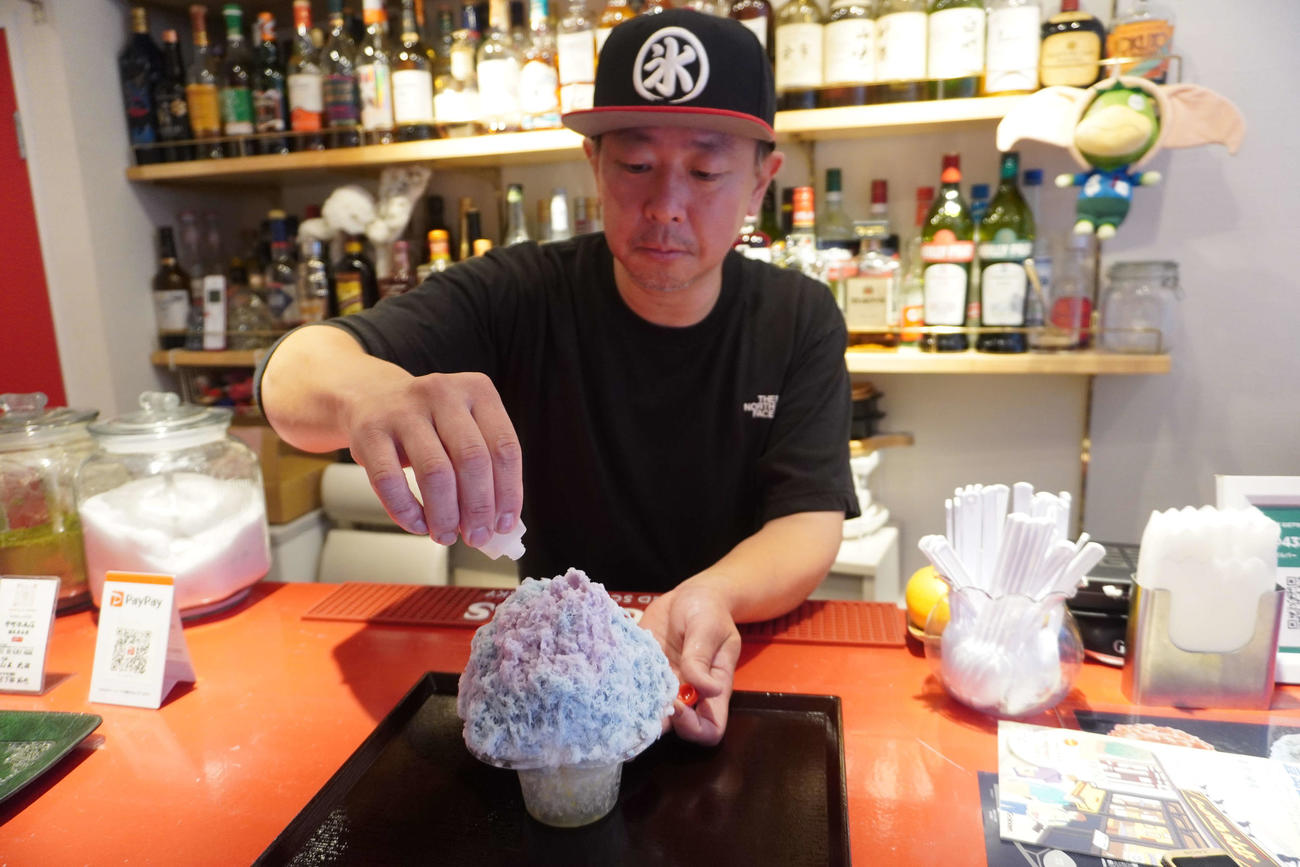 シロップをかけると色が変化するかき氷「マジックバタフライ」を販売する「中町氷菓店　練馬豊島園」の日下部拓也さん（撮影・沢田直人）