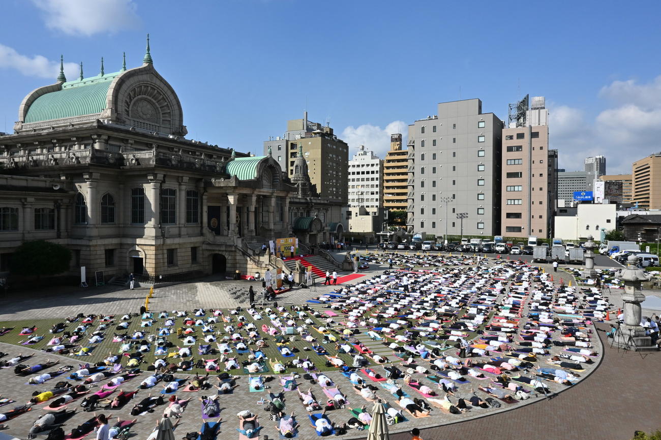 21日早朝、国際ヨガデーに築地本願寺では境内に寝ころんで650人が同時にヨガを楽しんだ（提供・築地本願寺）