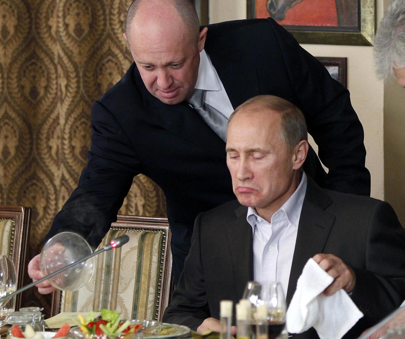 11年11月、モスクワ郊外にある自身のレストランで、プーチン・ロシア首相（当時、右）に給仕をするプリゴジン氏（AP）