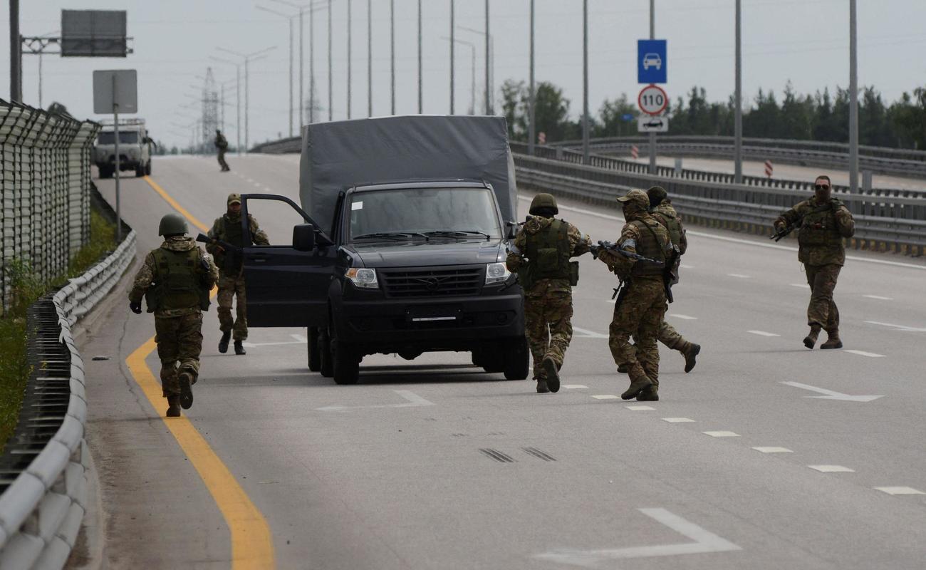 ロシア南部とモスクワをつなぐ道路で車両の近くを歩くワグネルの戦闘員＝24日、ロシア・ボロネジ近郊（ロイター＝共同）