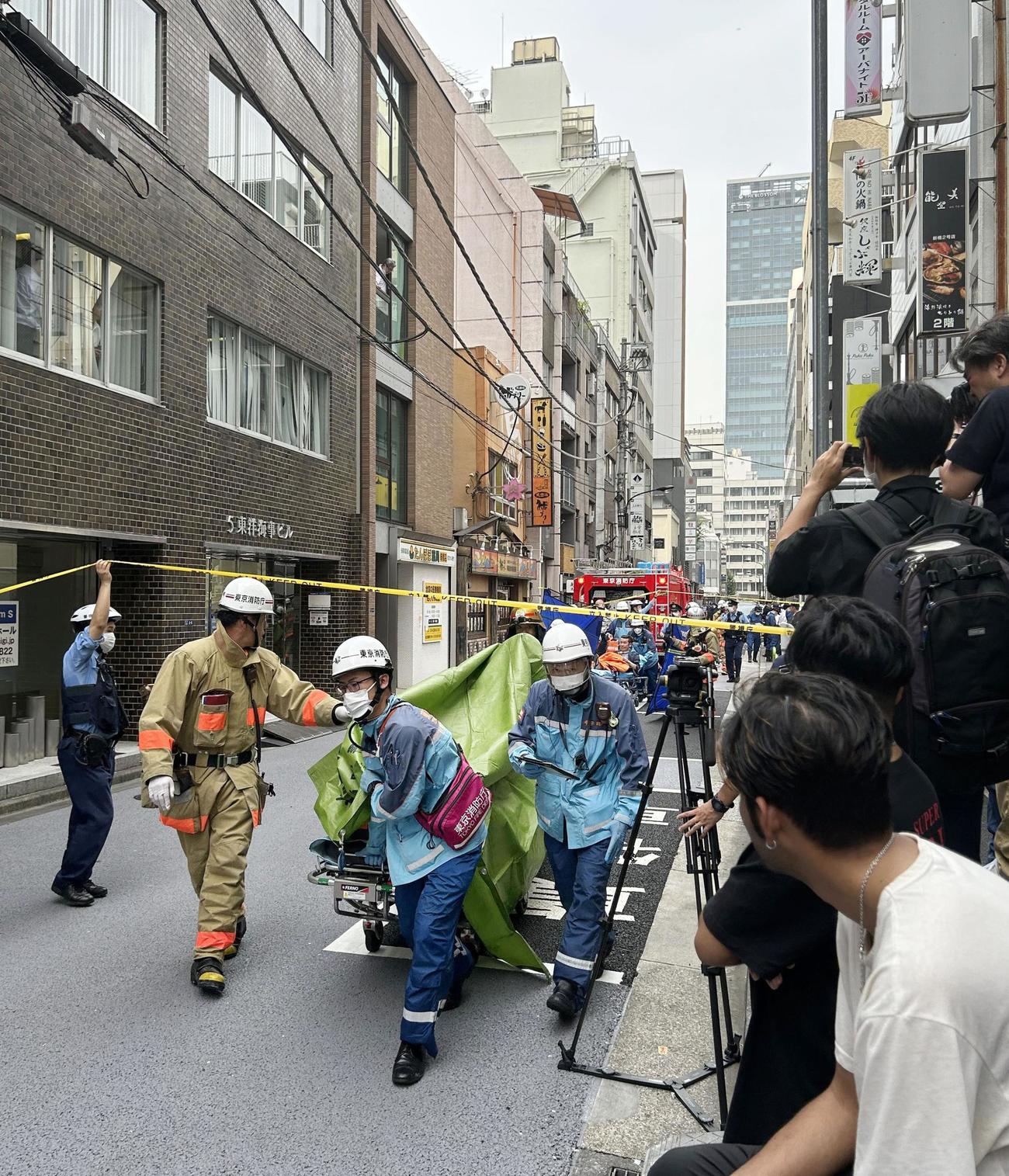 東京・新橋でけが人を搬送する消防隊員ら（共同）
