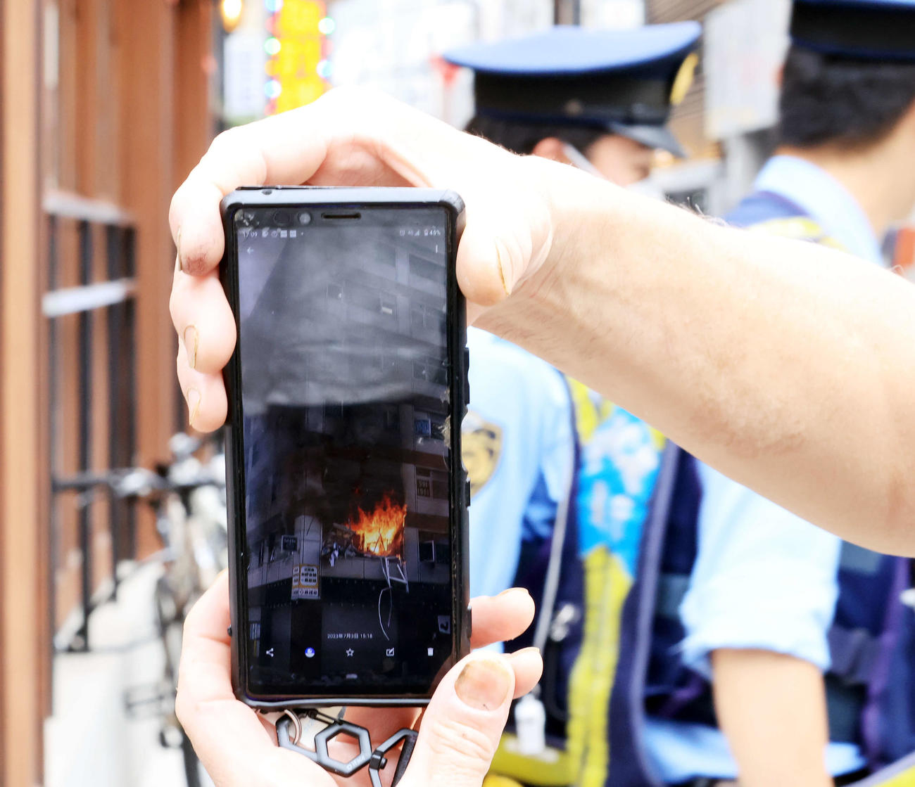 新橋のビル2階の爆発現場付近で、自身が撮影した映像を見せて説明する人も（撮影・浅見桂子）