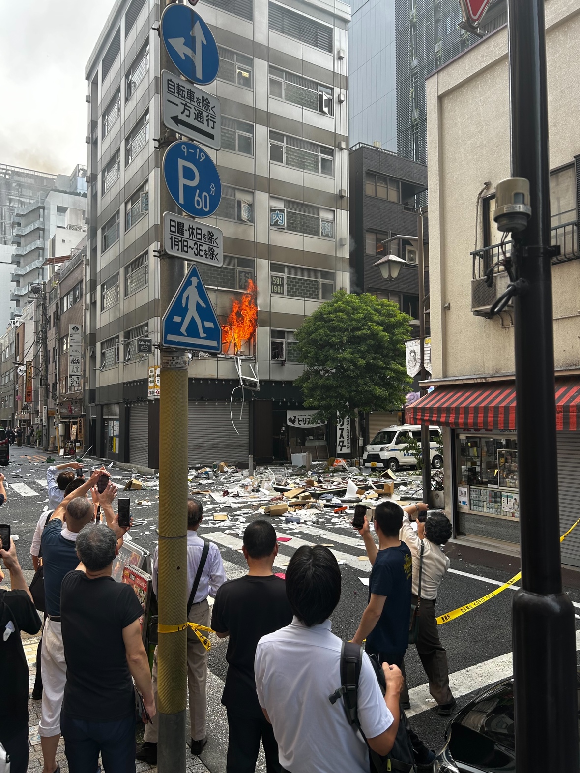道路に破片が散乱し、炎が立ち上がる新橋の爆発現場（目撃者提供）