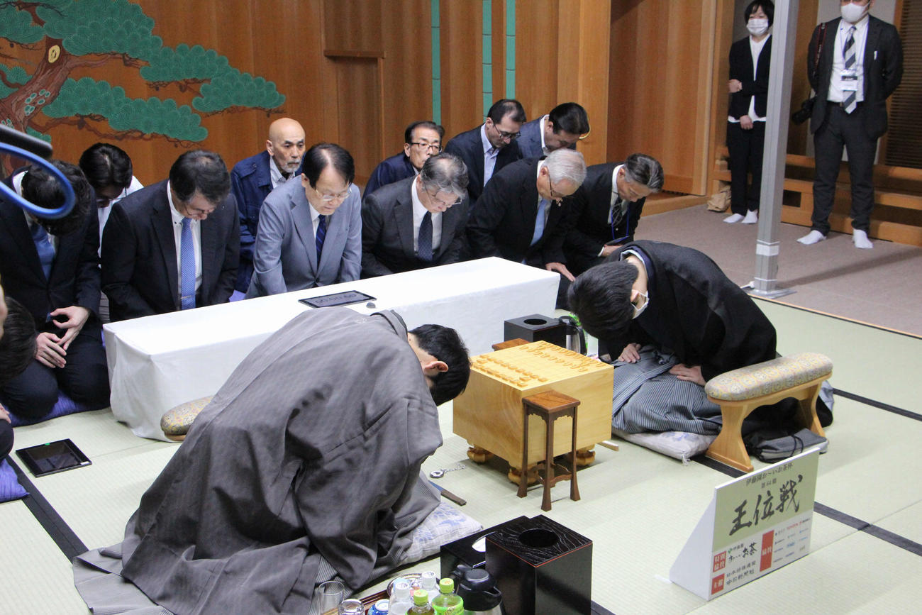 豊田市能楽堂での「伊藤園お～いお茶杯第64期王位戦7番勝負第1局」に臨む藤井聡太王位（右）、佐々木大地七段（日本将棋連盟提供）