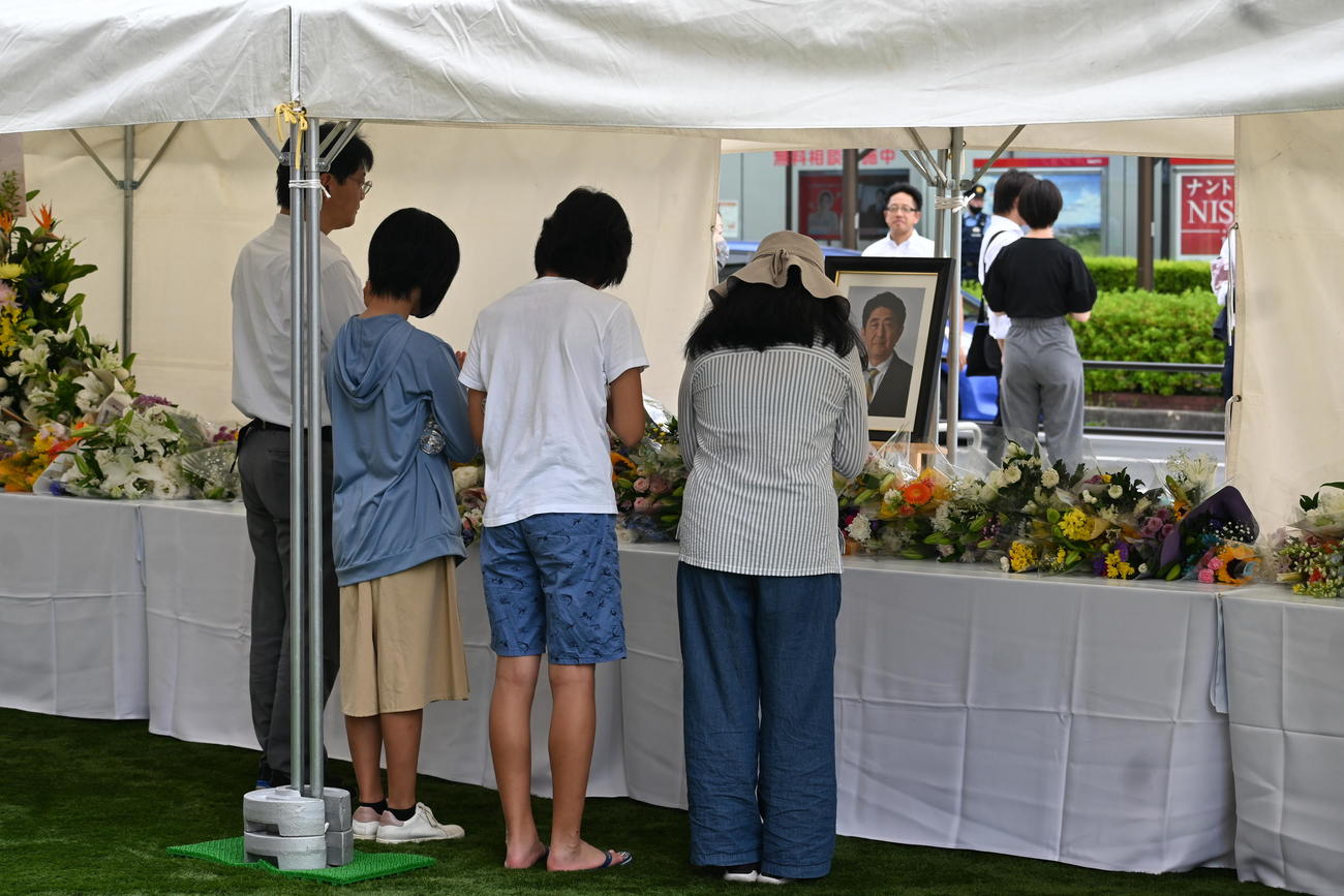 近鉄大和西大寺駅前（北口）の事件現場近くに設営された献花台で手を合わせる市民ら（撮影・松浦隆司）