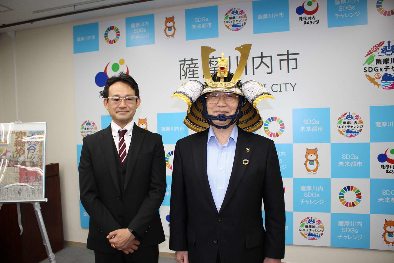 甲冑工房丸武の田ノ上智隆社長（左）と兜をかぶった薩摩川内市の田中良二市長
