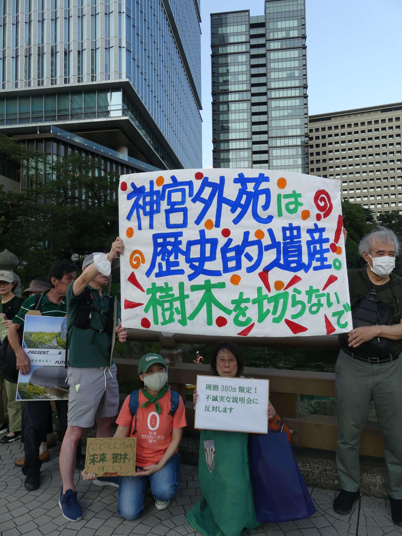 神宮外苑再開発をめぐる事業者による住民説明会の会場前で、反対の声をあげる人々