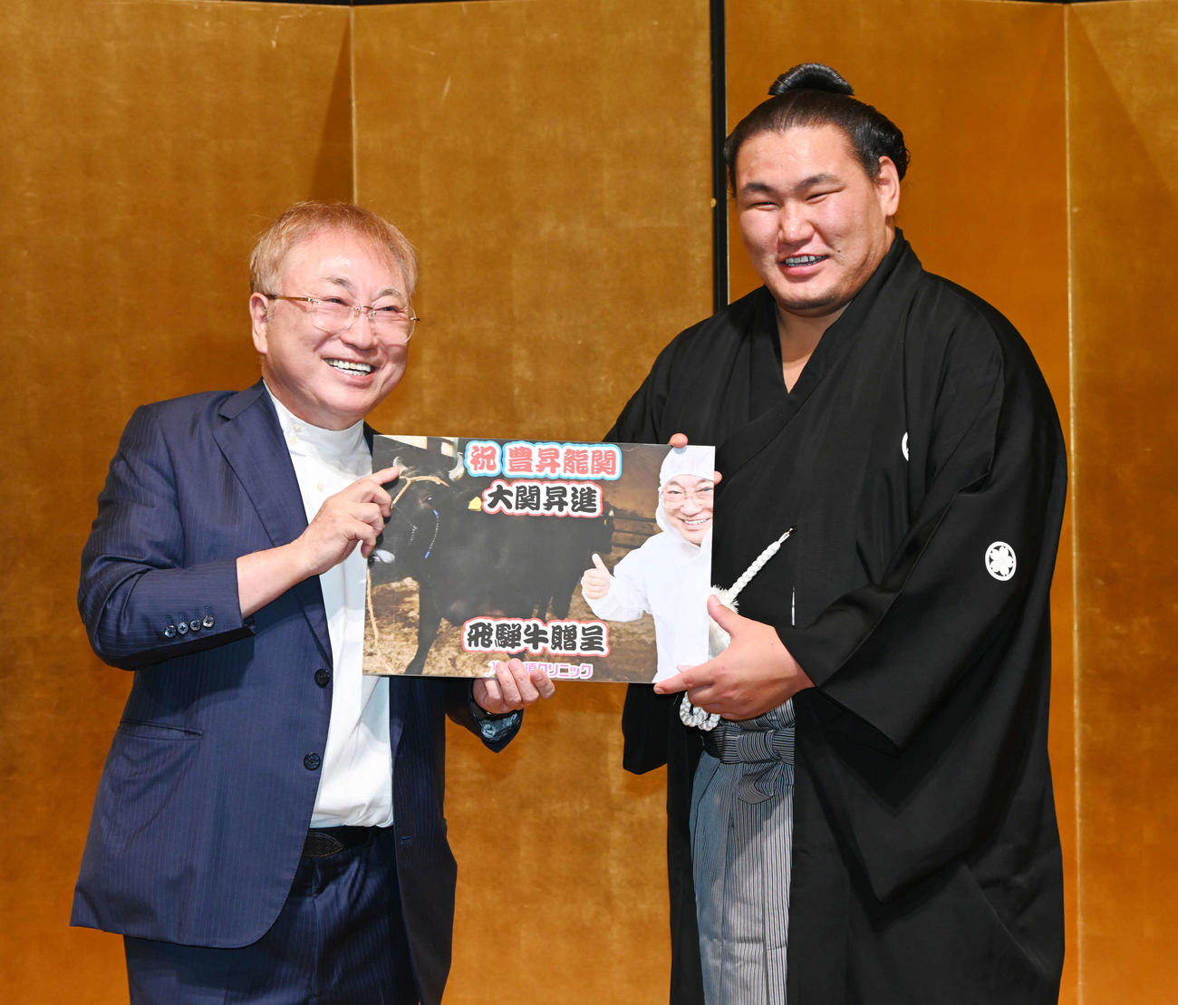 祝勝会場で高須クリニックの高須克弥院長（左）から大関昇進祝いの目録を贈呈される豊昇龍