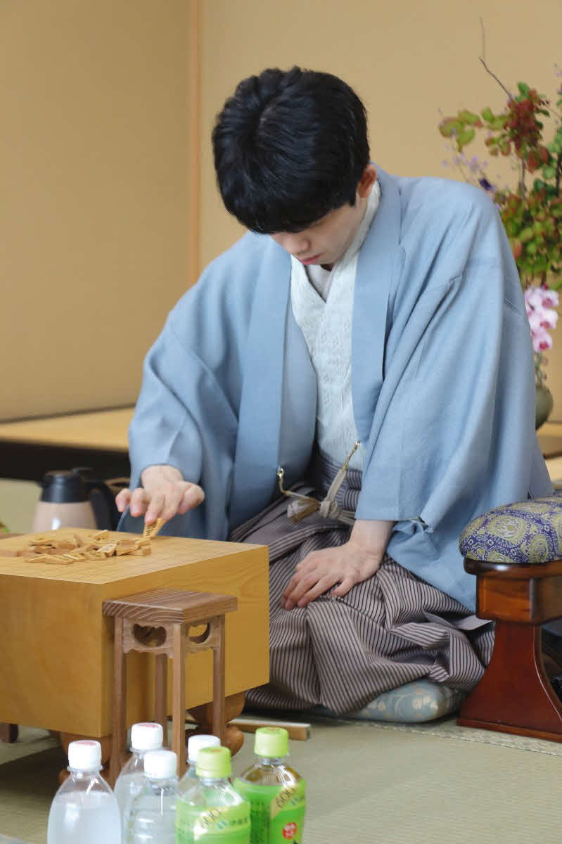 2日目の再開を前に駒を並べる藤井聡太王位（日本将棋連盟提供）