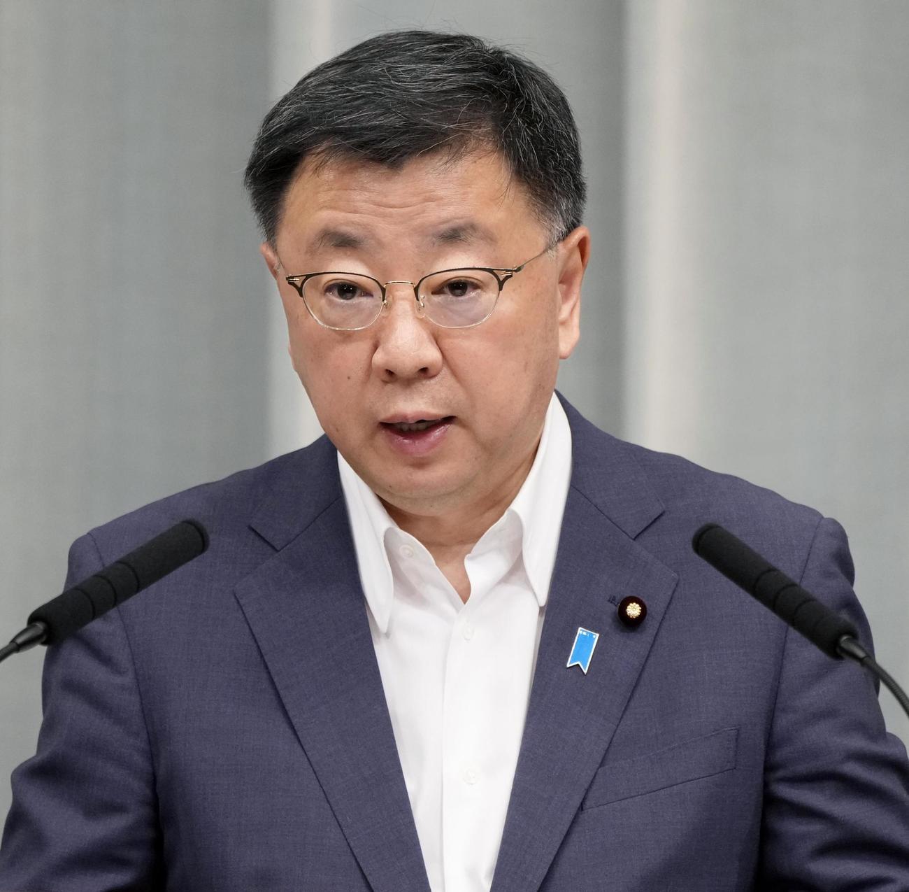 記者会見する松野官房長官（共同）