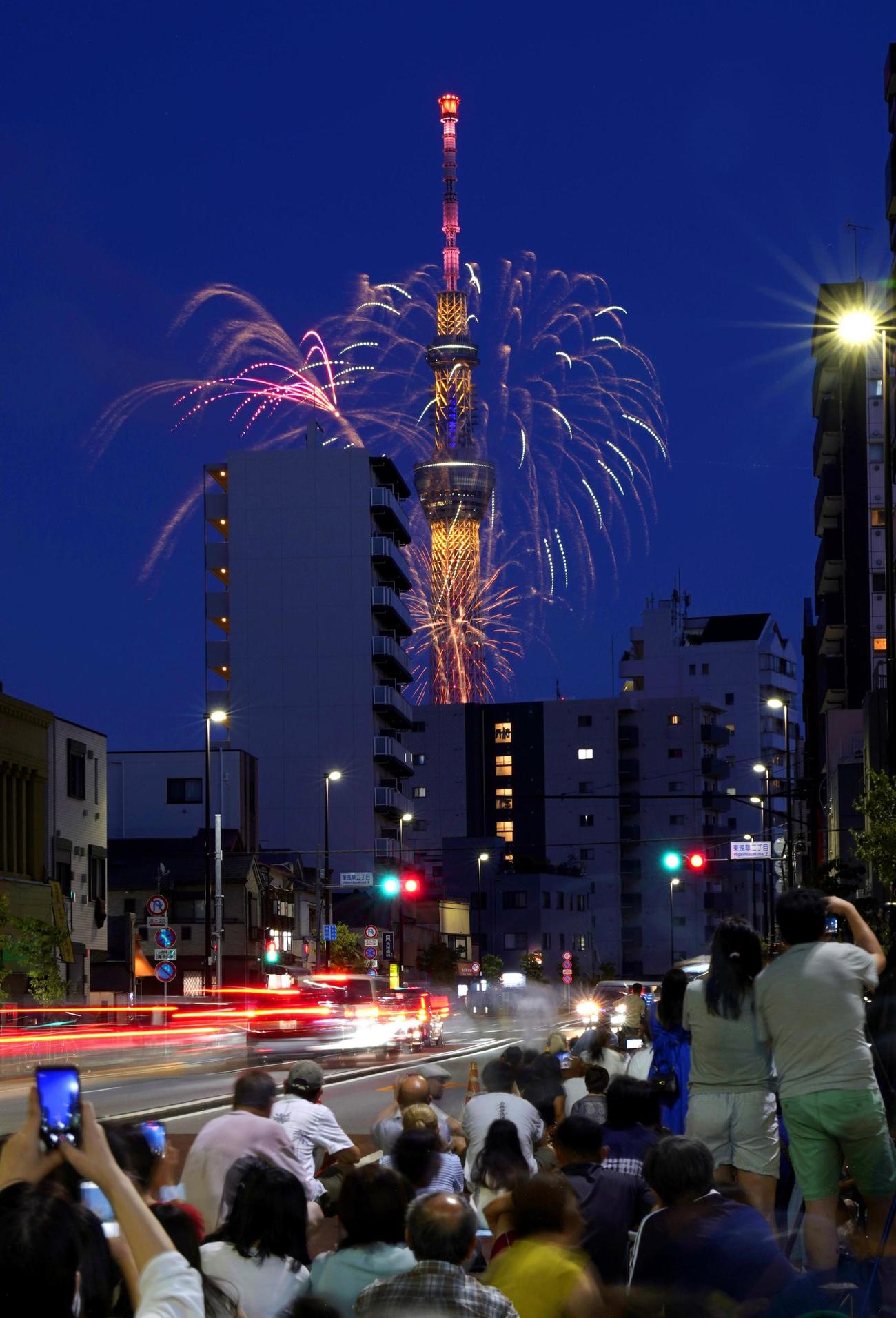夜空を彩る隅田川花火大会の花火と東京スカイツリー。路上は多くの見物客でにぎわった（共同）