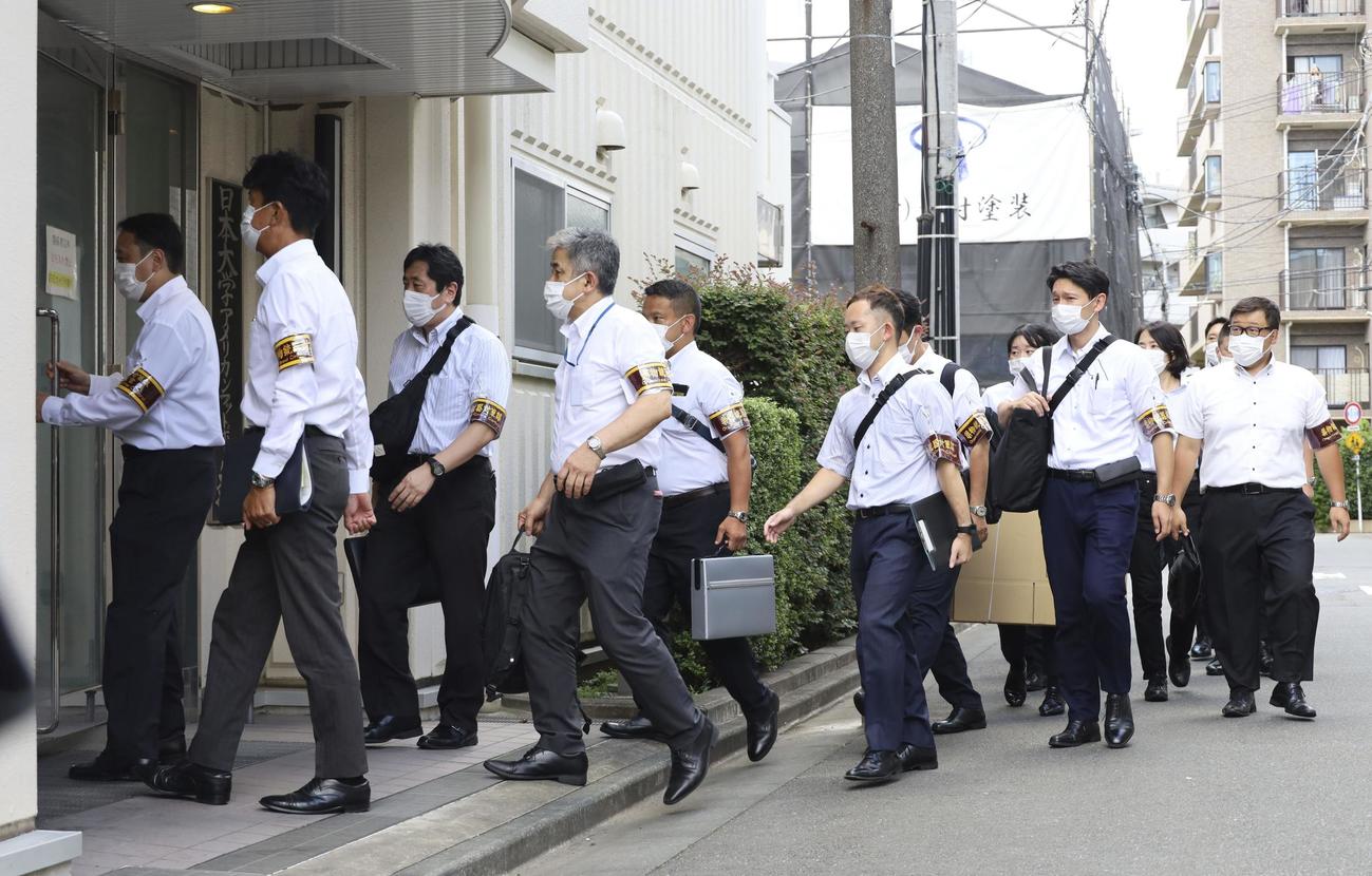 日本大アメリカンフットボール部の寮に家宅捜索に入る警視庁の捜査員ら＝3日午後1時ごろ、東京都中野区（共同）