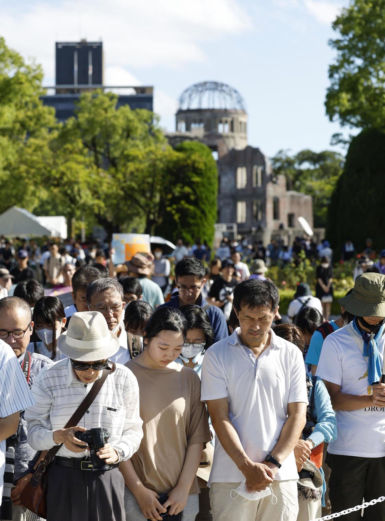 被爆から78年を迎え、原爆投下時刻に黙とうする人たち。奥は原爆ドーム（共同）