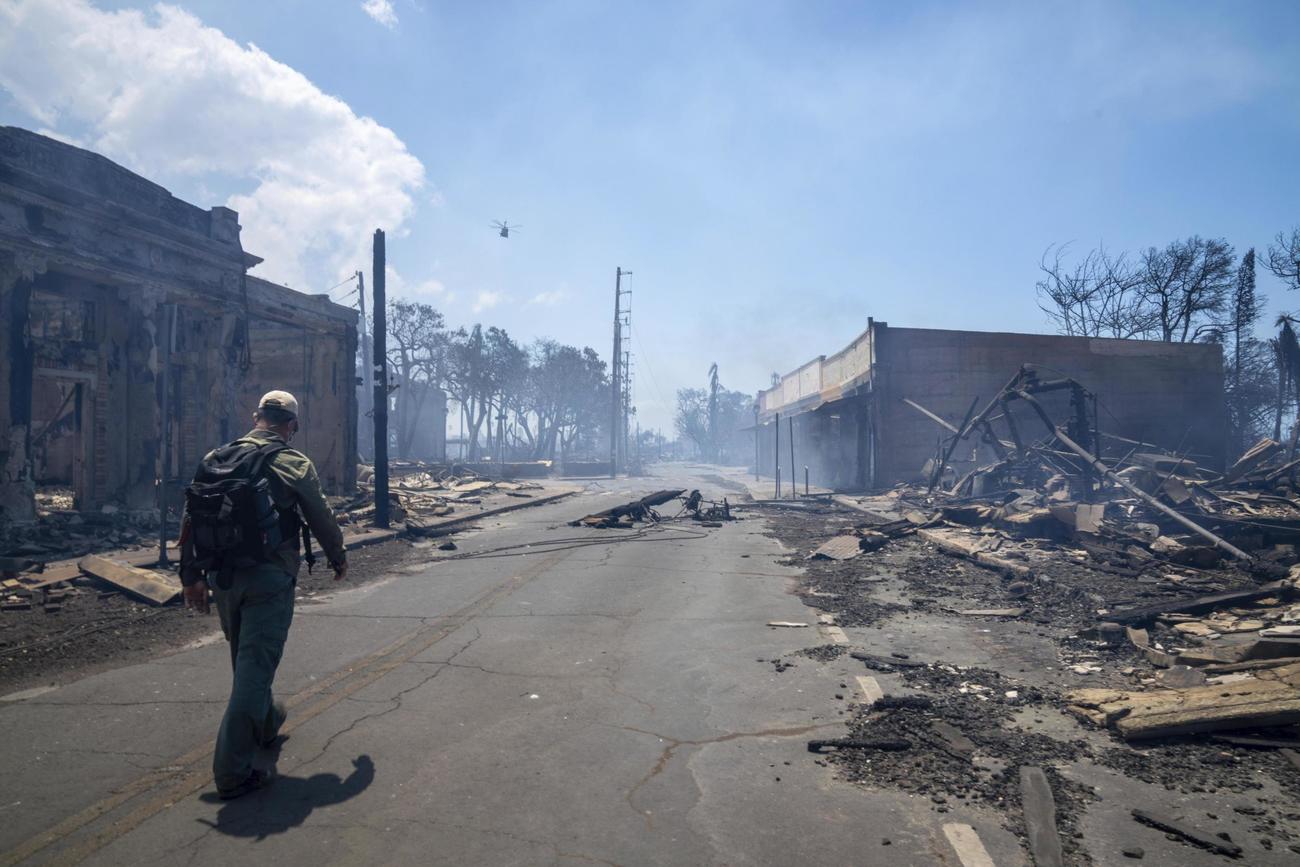 山火事で建物が焼失するなどした米ハワイ・マウイ島ラハイナを歩く男性＝9日（TIFFANY・KIDDER・WINN提供、AP＝共同）