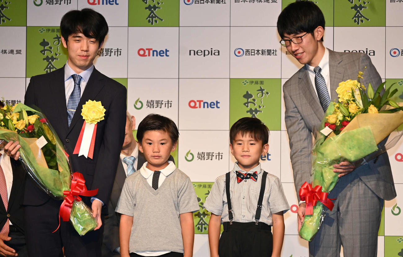 前夜祭で地元の小学生から花束を贈られた藤井聡太王位（左）と佐々木大地七段（撮影・松浦隆司）