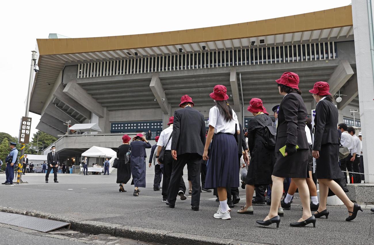 全国戦没者追悼式が開かれる東京・日本武道館（奥）に向かう参列者（共同）
