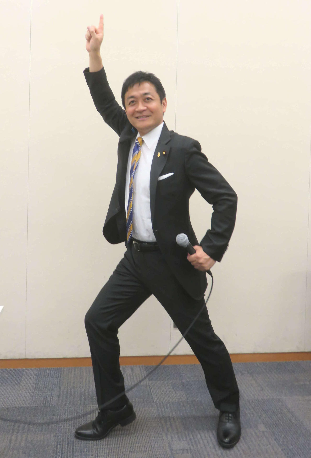 玉木雄一郎代表はマイクを手にトラボルタばりのポーズで再選アピール（撮影・大上悟）
