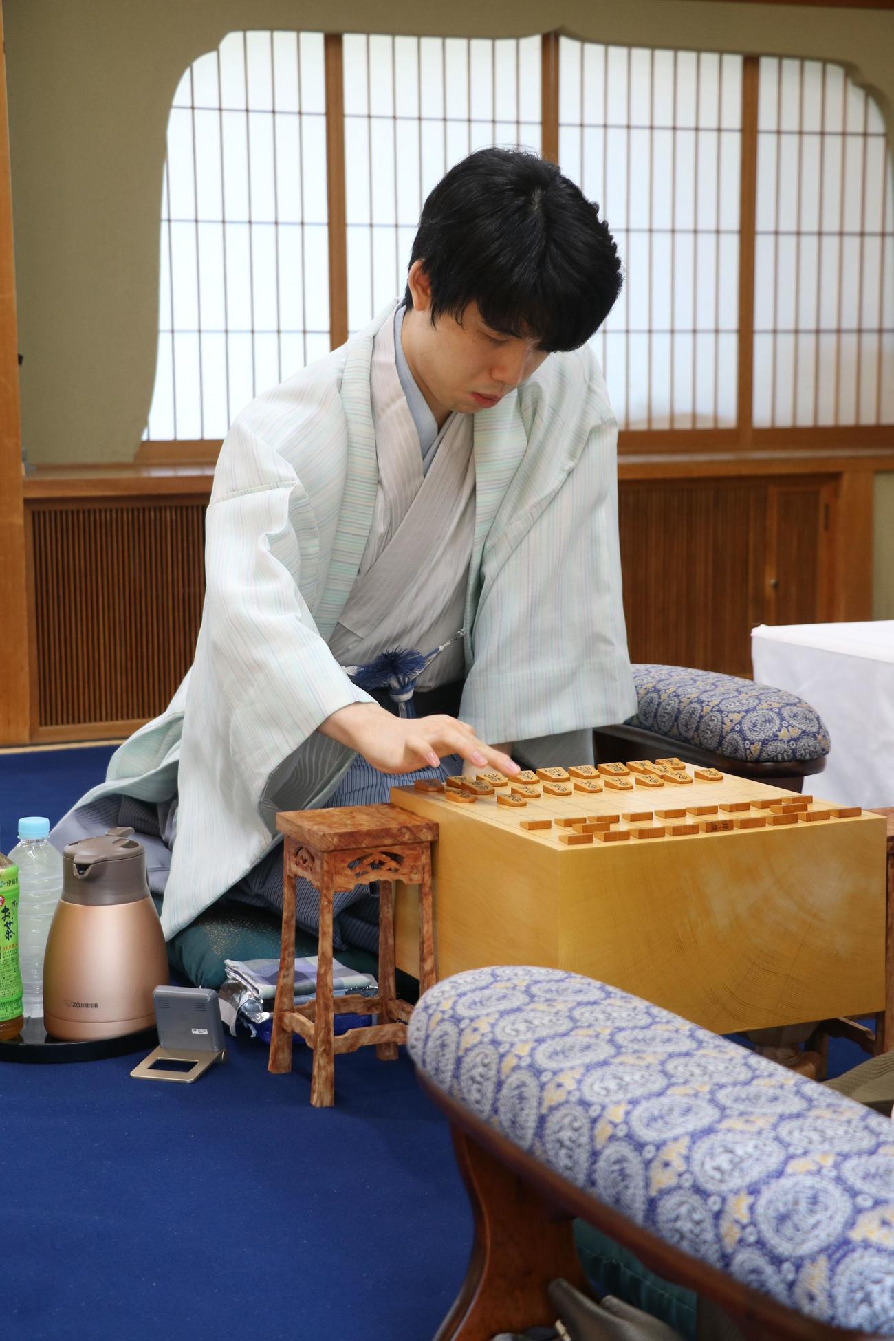 王位戦7番勝負第5局、初手を指す藤井聡太王位（日本将棋連盟提供）