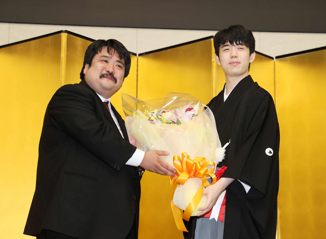花束を手に写真に納まる藤井叡王（右）と鈴木もぐら（撮影・鈴木正人）
