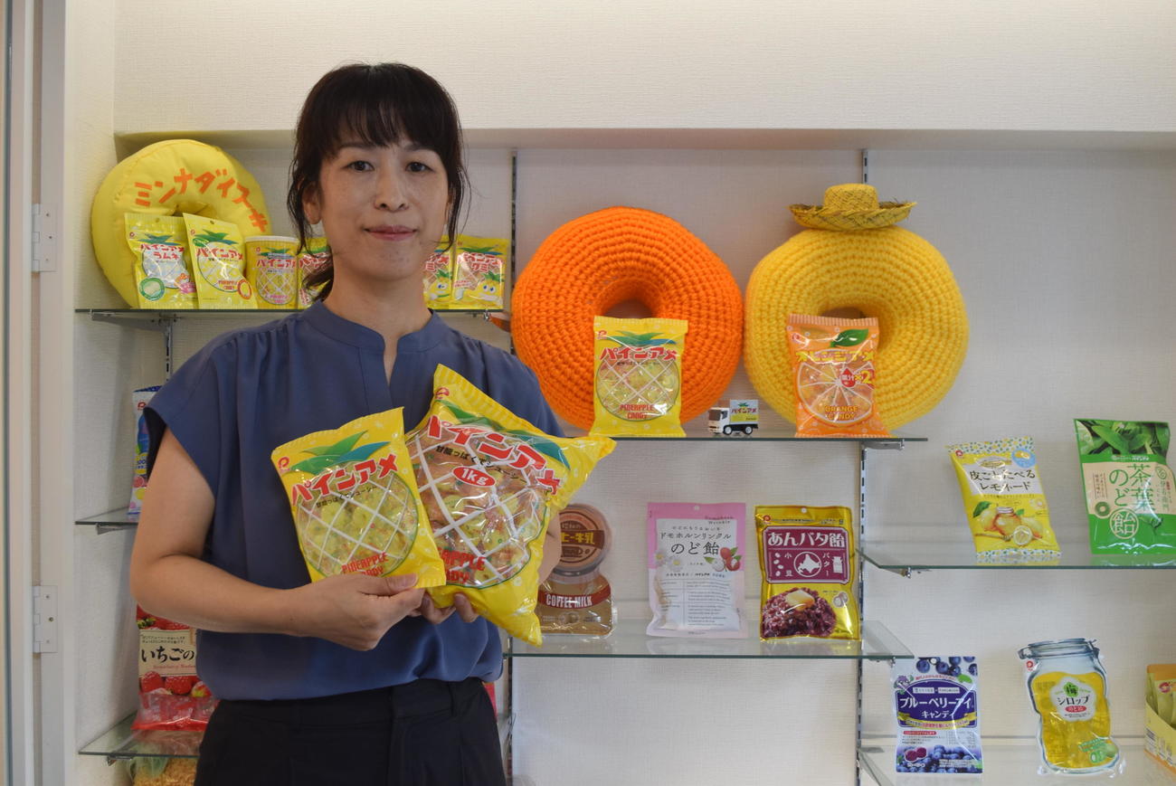 パインアメを持つパイン株式会社広報室室長の井守真紀さん（撮影・阪口孝志）