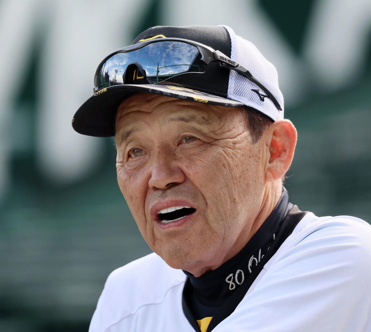 阪神対巨人　アルプススタンドのイスに腰掛けて話す岡田監督（撮影・加藤哉）
