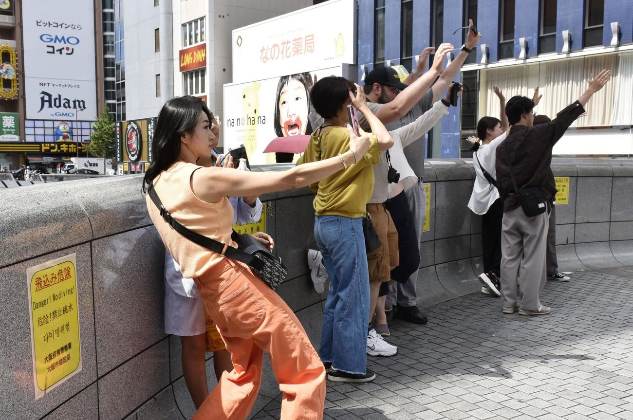 大阪・道頓堀の戎橋。「飛込み危険」と書かれた注意書きが掲示されている