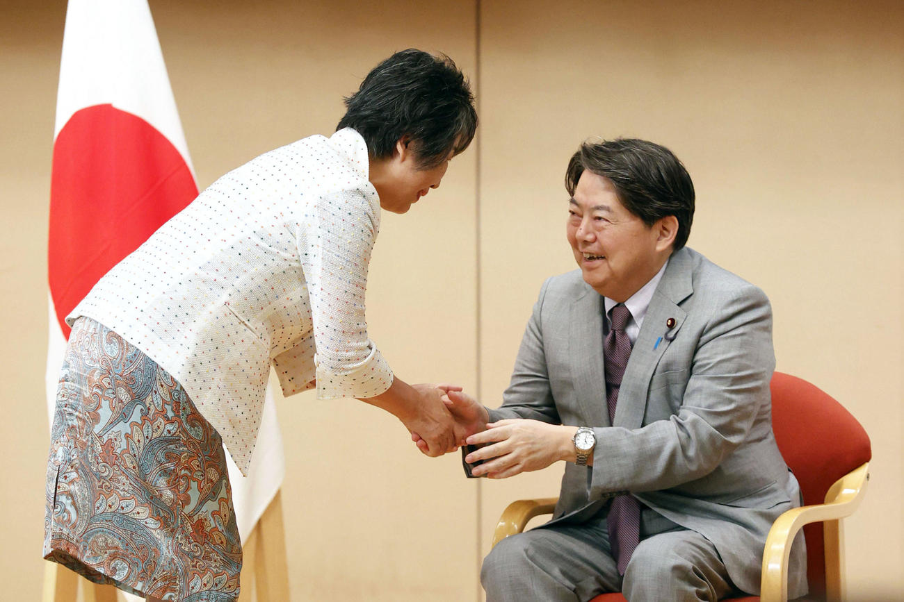 交代式で上川外相（左）と握手する林前外相（共同）