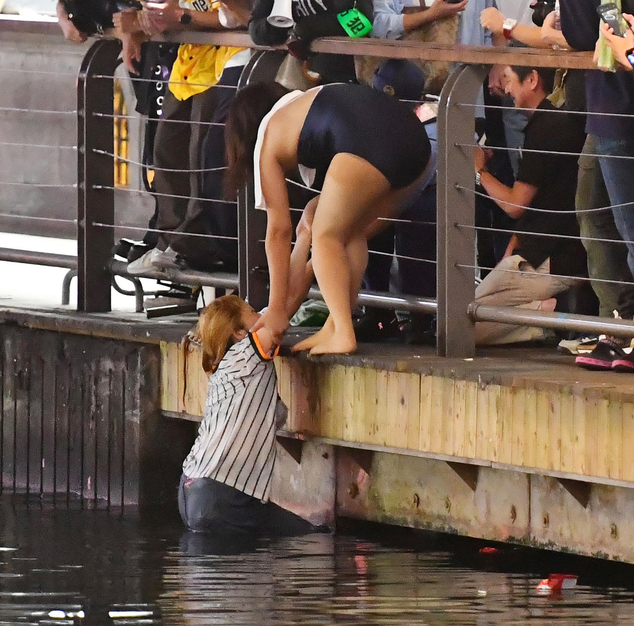 道頓堀に飛び込んだ女性を上げるのを手助けする水着女性（撮影・清水貴仁）