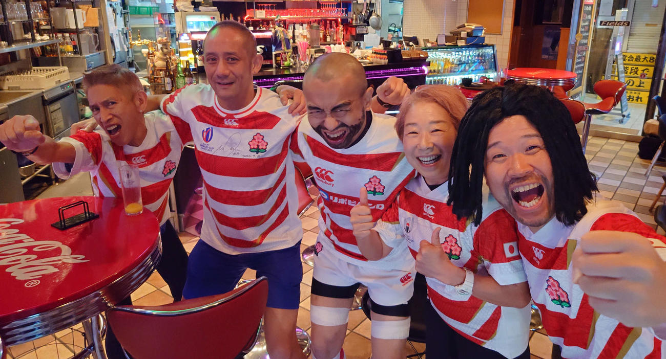 日本代表の勝利でフィールズ渋谷にいた5人が肩を組んだ。左から田中守店主、後藤慶太さん、ZZマイケル、池田敦子さん、ホリエモン翔太ことクロワッサン。（撮影・寺沢卓）