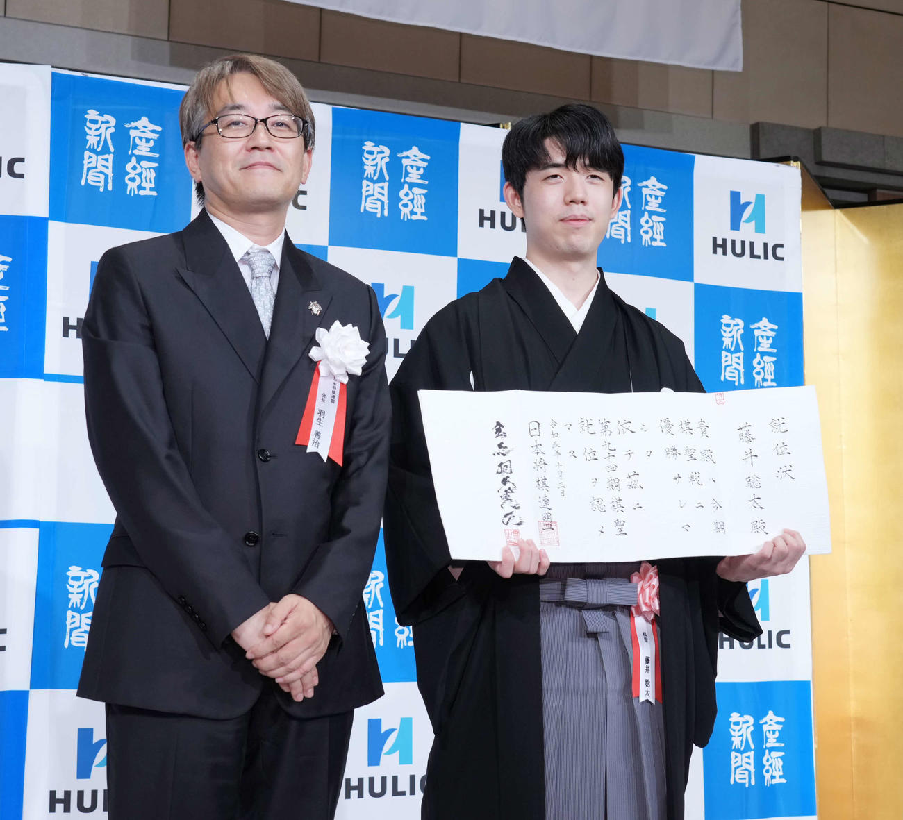 第94期ヒューリック杯棋聖就位式で日本将棋連盟の羽生会長（左）から就位状の贈呈を受ける藤井棋聖（撮影・小沢裕）