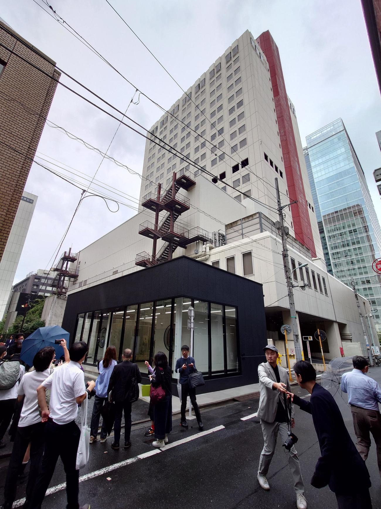 報道陣に公開されたシャトル（手前の黒い建物）と松竹本社の入っている東劇ビル（撮影・寺沢卓）