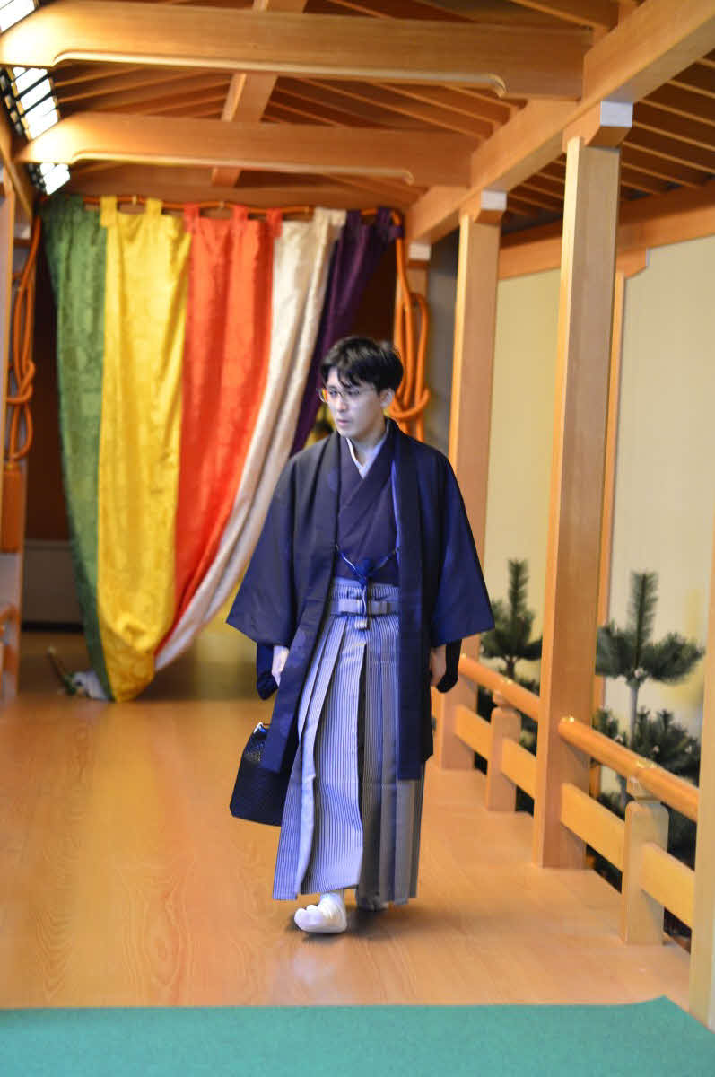 対局場となる「セルリアンタワー能楽堂」への廊下を歩む挑戦者の伊藤匠七段（日本将棋連盟提供）